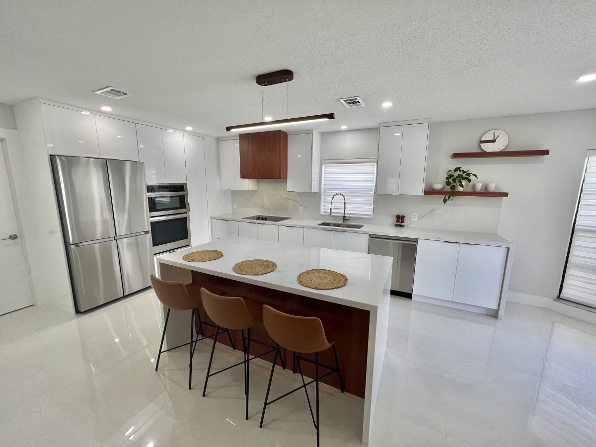 Modern white kitchen with a custom island and warm wood accents built by H&D Florida Carpentry